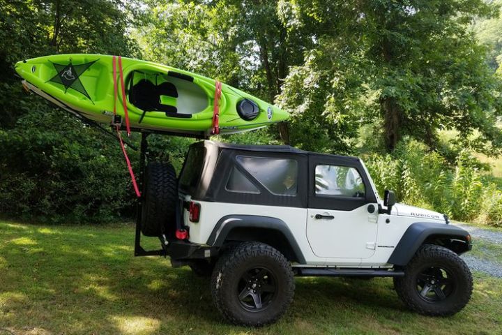 a green truck parked in front of a car